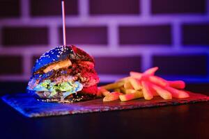 Delicious hamburger and fried potato on board photo