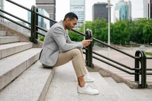 Man sitting on stairs using smartphone photo