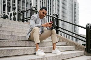 Man sitting on stairs using smartphone photo
