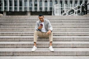 Man sitting on stairs using smartphone photo