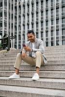 Man sitting on stairs using smartphone photo