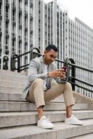 Man sitting on stairs using smartphone photo