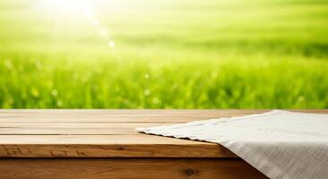 Wooden table top on blurred green field background to product showcase photo