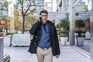 A man in a coat and tie talking on a cell phone photo