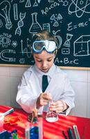 A young boy in a lab coat and goggles is working on a project photo