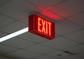Red Exit Sign Glows Brightly Overhead photo