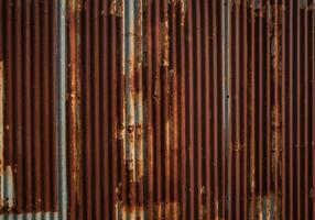 Rustic corrugated metal wall texture shows richly textured rust patterns in warm light photo