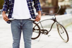 I Have No Money. Closeup of unrecognizable black man in blue casual style shirt showing his empty pockets in the street photo