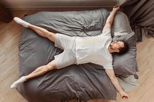 Fast Asleep Man Sleeping Lying On His Back In Bed Resting At Home. Healthy Sleep Concept. Top View photo