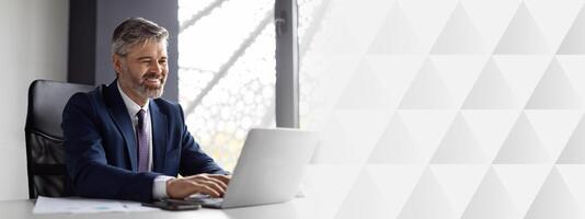 Smiling Middle Aged Businessman Working With Laptop Computer In Office, Handsome Man Entrepreneur In Suit Sitting At Desk And Typing On Keyboard, Enjoying Corporate Communication, copy space photo