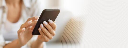 Unrecognizable Woman Using Modern Smartphone While Sitting On Couch At Home, Closeup Shot Of Lady Hands Holding Cellphone, Young Woman Browsing App On Mobile Phone Or Shopping Online, Cropped photo