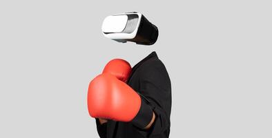 A person is using virtual reality goggles while wearing red boxing gloves. The individual is isolated against a neutral background, emphasizing the modern technology and immersive experience. photo