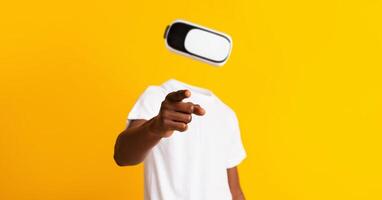 A user is immersed in virtual reality, pointing with one hand while wearing a headset. The vivid yellow background highlights the modern technology used for augmented reality exploration. photo