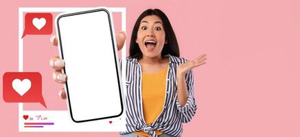 An influencer is joyfully displaying a blank smartphone in her hand against a vibrant pastel background. She exudes excitement, demonstrating her connection with social media and chat applications. photo