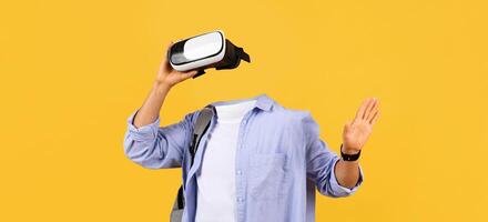 A user enjoys virtual reality through goggles, fully engaged in an immersive experience. The bright yellow background enhances the modern gadget's appeal, showcasing the technology's allure. photo