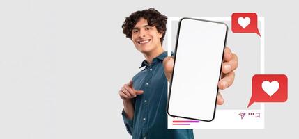 An influencer is smiling while holding a smartphone displaying a blank screen. The backdrop is neutral, with visual elements representing social media interactions. photo