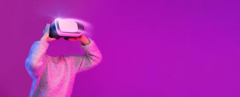 A user engages in an immersive experience with a modern virtual reality headset, fully absorbed in virtual environments. The vibrant background adds to the futuristic vibe, enhancing the activity. photo