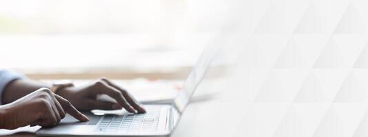 Closeup of unrecognizable black woman working on laptop, typing on computer keyboard while working in office, side view, cropped image photo