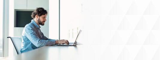 Profile Side View Portrait Of Focused Man Manager Working On Laptop Computer In Modern Office, Serious Guy Sitting At Desk And Using Pc, Businessman Typing On Keyboard, Checking Corporate Email photo
