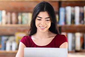 Remote Work Concept. Smiling Korean Girl Using Laptop In Cafeteria, Working Online, Copy Space photo