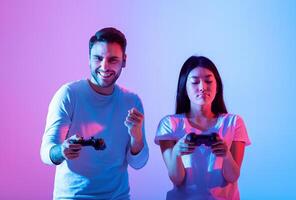 Two friends engage in a competitive gaming session, surrounded by vibrant lighting. The man player appears excited while the woman player focuses intently on the game. photo