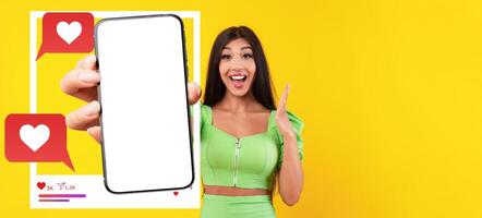 An influencer in a vibrant outfit happily displays a smartphone with a blank screen, inviting viewers to imagine their own app content. photo