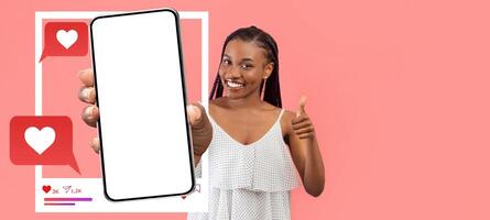 A smiling influencer holds a blank smartphone, ready to engage with followers. The background features colorful chat bubbles with hearts, emphasizing social media interaction. photo