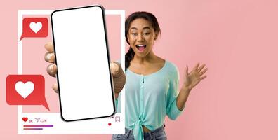 An energetic influencer is holding a smartphone, displaying a blank screen for a new app. She expresses excitement, showcasing the interaction with online messaging and social media. photo