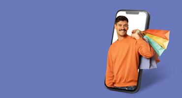 A buyer is engaging in online shopping through a smartphone with a large screen. The person holds colorful shopping bags, showcasing the convenience of digital commerce in a modern setting. photo