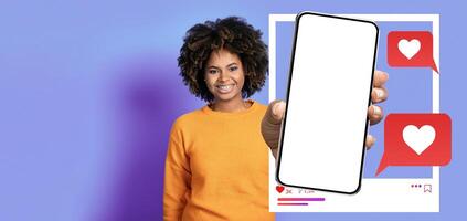 An influencer smiles while holding a smartphone in front of a vibrant background. The screen displays a mockup of social media interactions, highlighting likes and messages. photo