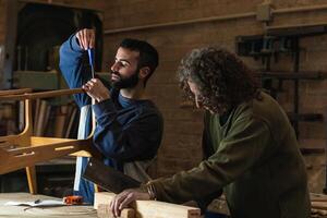 Male artisans creating wooden furniture in workshop photo