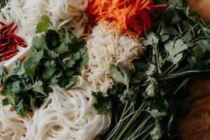 A bunch of noodles and vegetables on a table photo