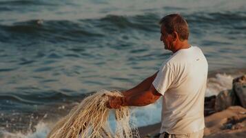 Fisherman mending net by ocean waves at dawn photo