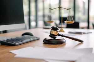 Judge's gavel on desk with scales and computer photo