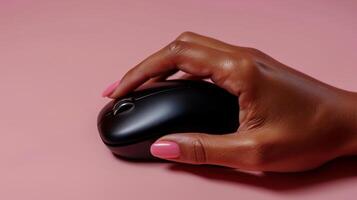 Close-up of a hand using a wireless computer mouse on a pink background photo