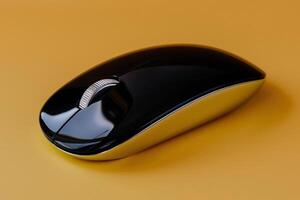 A black and gold computer mouse on a yellow background photo