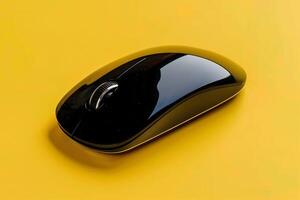 A black computer mouse on a yellow background photo