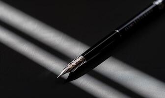 Elegant black fountain pen with silver nib, angled on a dark surface, illuminated by sunlight photo