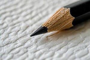 Close-up of a sharpened pencil tip on textured paper photo
