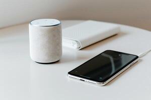 Wireless speaker, phone, and notebook on a table photo