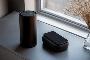 Modern wireless speaker and phone charging pad on a windowsill photo