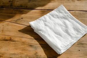 Stack of white paper napkins on a wooden table photo