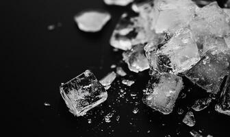 Close-up of ice cubes scattered on a dark surface photo