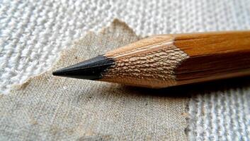 Close-up of a sharpened pencil on textured fabric photo