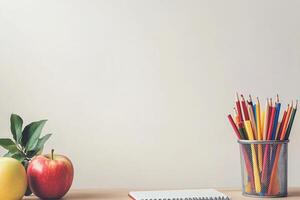 Simple study desk setup with colored pencils, apples, and notebook photo