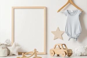 Simple nursery decor. Blank frame, baby clothes, wooden toys photo