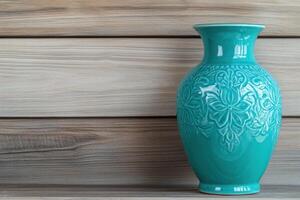 Beautiful turquoise ceramic vase with embossed floral patterns elegantly showcased on a rustic wooden shelf in a warm, inviting atmosphere photo