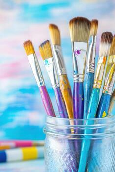 bien usado pinceles arreglado dentro vaso frasco, vistoso pintar tubos tendido en el mesa agregando artístico vibras, capturar el esencia de el creativo artístico proceso foto