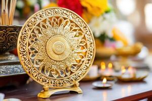 Intricately carved golden Dharma Wheel on an altar surrounded by incense and candles in a serene Buddhist setting photo