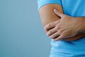 Close-up view of athlete in pain with swollen joint, focusing on injury to elbow during training session photo